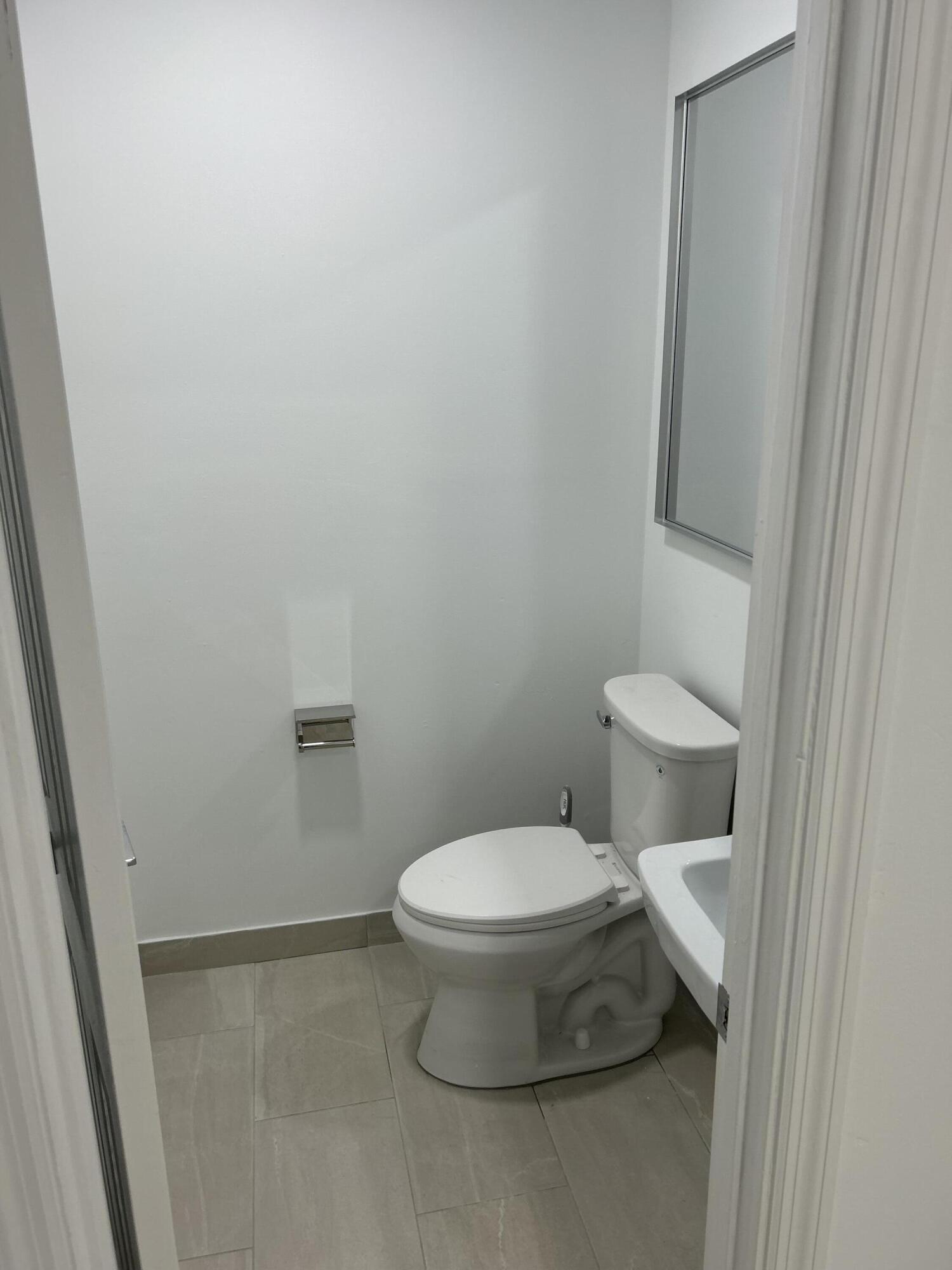 500 Commerce Way West, Unit 8 Jupiter, FL 33458 - Photo 8 of 9 a white toilet sitting next to a shower