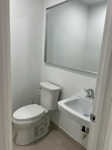 a white toilet sitting next to a white sink