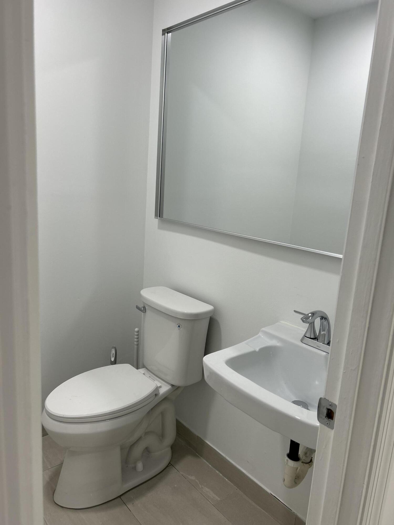 500 Commerce Way West, Unit 8 Jupiter, FL 33458 - Photo 9 of 9 a white toilet sitting next to a white sink