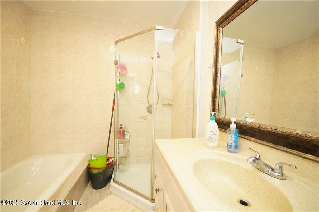301 Lightner Avenue Staten Island, NY 10314 - Photo 9 of 17 a bathroom with a tub sink and mirror