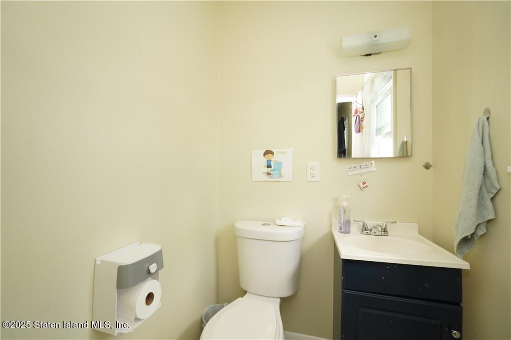 301 Lightner Avenue Staten Island, NY 10314 - Photo 10 of 17 a bathroom with a toilet a sink a mirror and vanity