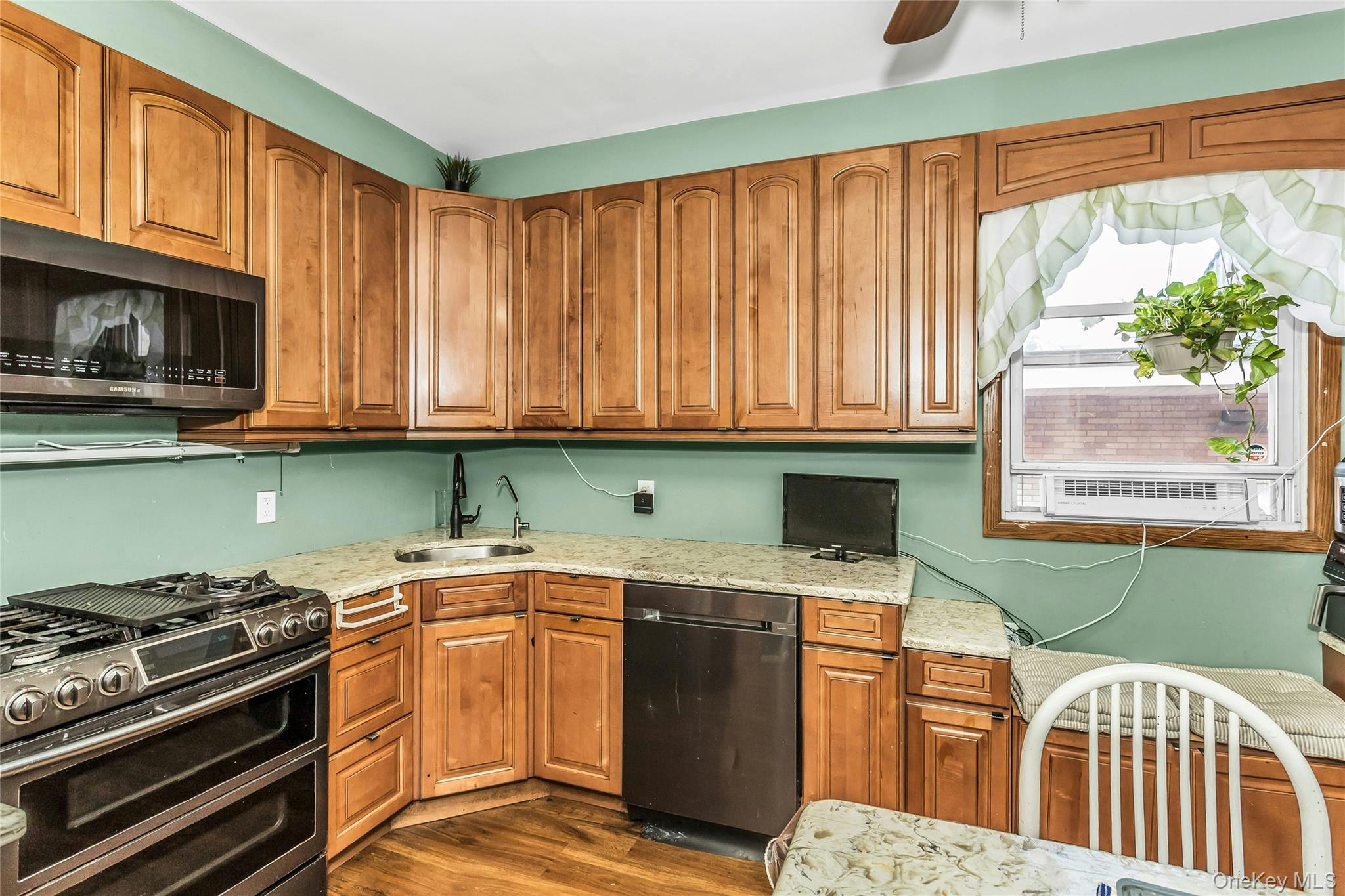 91-15 79th Street Queens, NY 11421 - Photo 7 of 11 a kitchen with stainless steel appliances granite countertop a stove a sink and a microwave