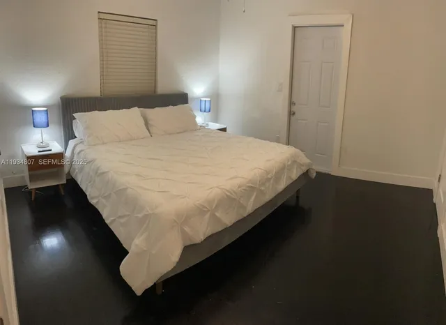 a large bed sitting in a bedroom next to a lamp