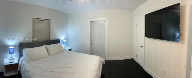 a bedroom with a bed and a flat tv screen