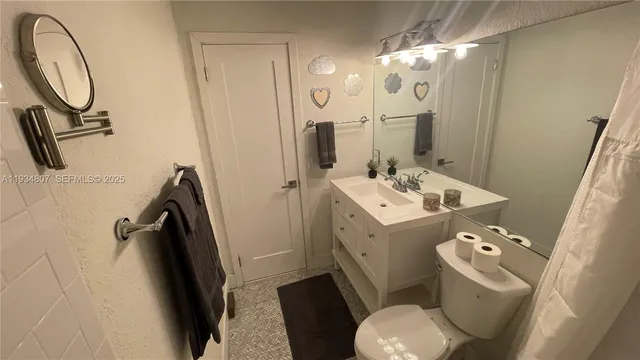 a bathroom with a sink mirror vanity and toilet