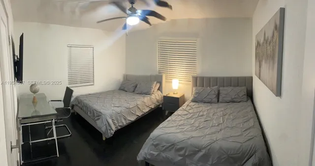 a bedroom with two beds and a window