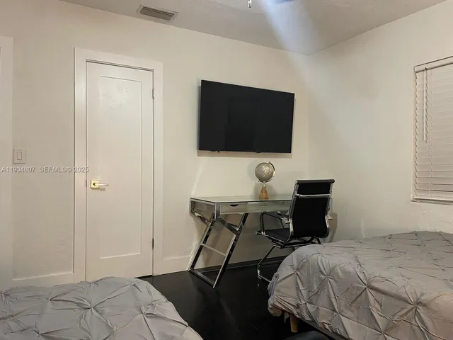 a bedroom with a bed and a flat screen tv