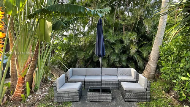 a backyard of a house with table and chairs barbeque oven