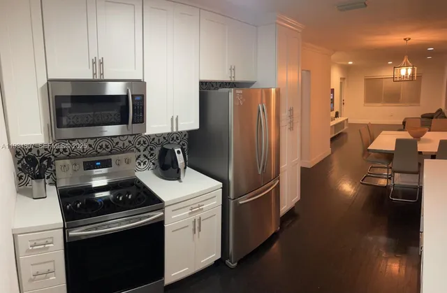 a kitchen with a refrigerator stove and cabinets