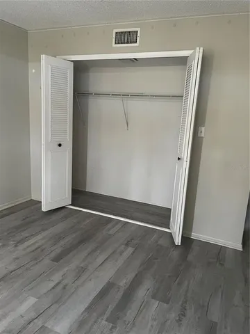 an empty room with wooden floor and closet