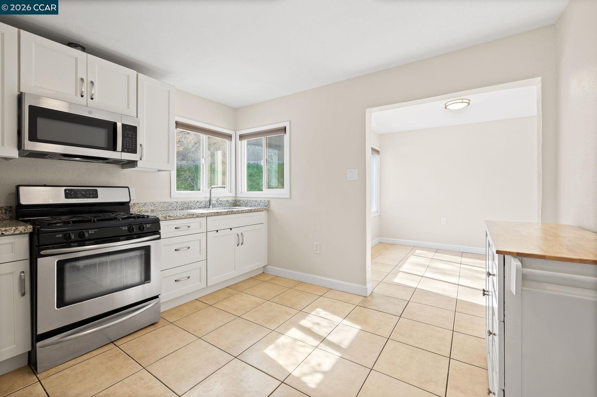 4820 Blum Road Martinez, CA 94553 - Photo 40 of 46 a kitchen with stainless steel appliances granite countertop a stove a microwave and a sink