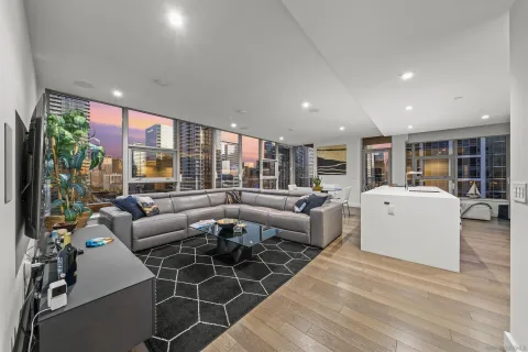 a living room with furniture floor to ceiling window and floor to ceiling window