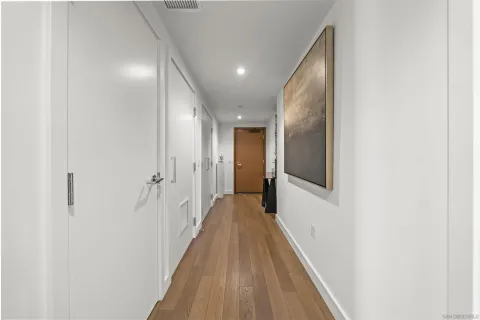 a view of a hallway with wooden floor