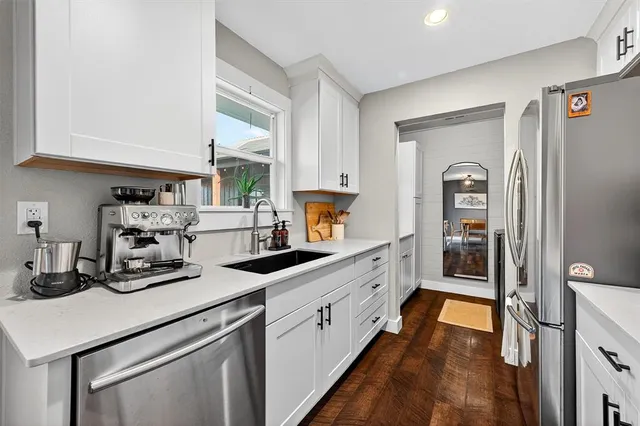 a kitchen with sink a refrigerator and cabinets