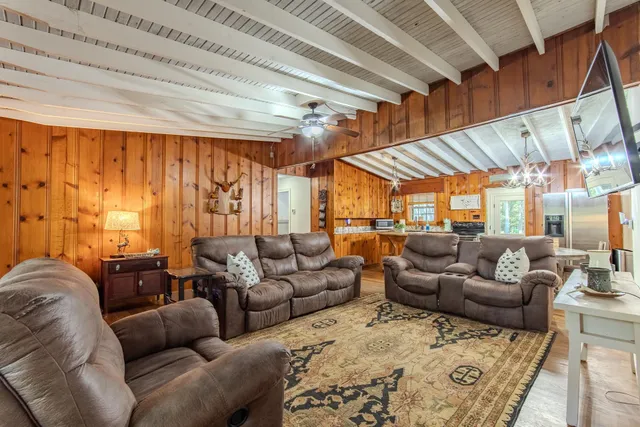 a living room with furniture a couch and a ceiling fan