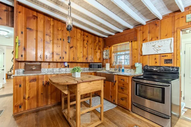 a kitchen with a stove a sink and cabinets