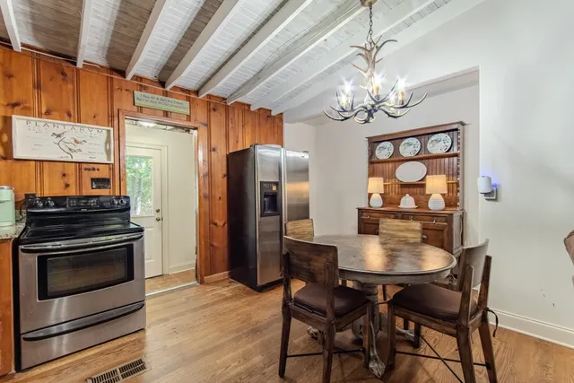 a view of a dining room with furniture a chandelier and wooden floor