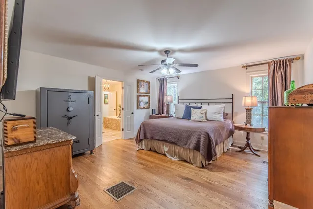 a spacious bedroom with a bed and wooden floor
