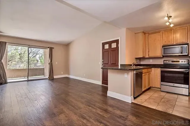 a kitchen with granite countertop a stove top oven and cabinets