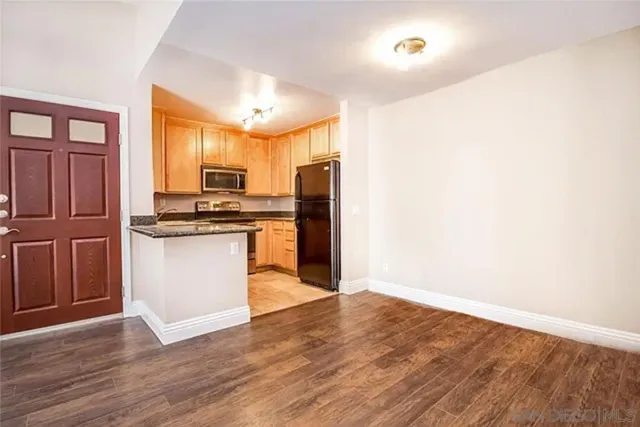 a kitchen with wooden floors and appliances