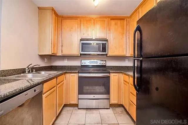 a kitchen with granite countertop a refrigerator and a sink