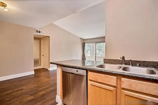 a kitchen with granite countertop kitchen island a sink appliances and a counter space
