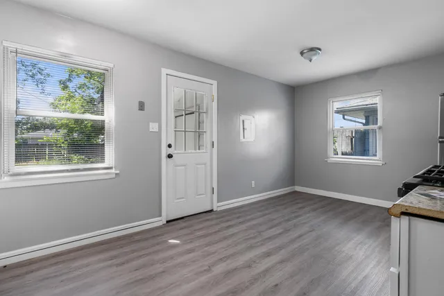 a view of a livingroom with wooden floor and windows