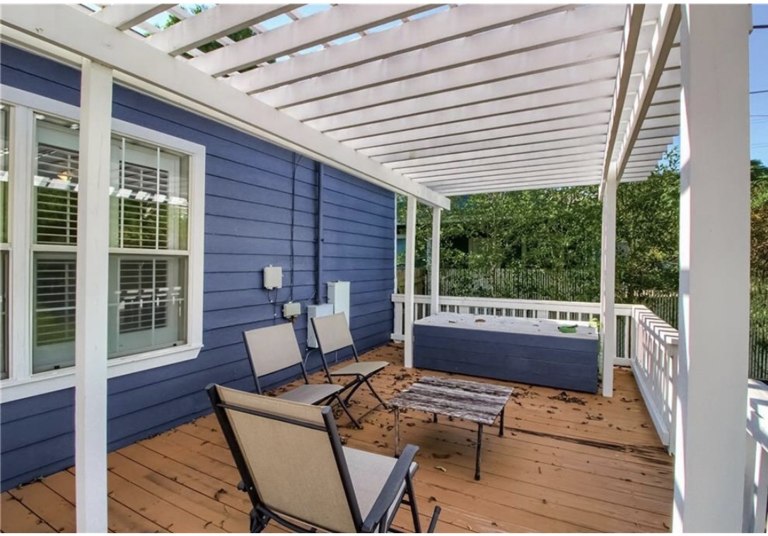 702 West N Loop Boulevard Austin, TX 78751 - Photo 22 of 23 Relax on the wooden deck under a classic pergola, ideal for unwinding outdoors.