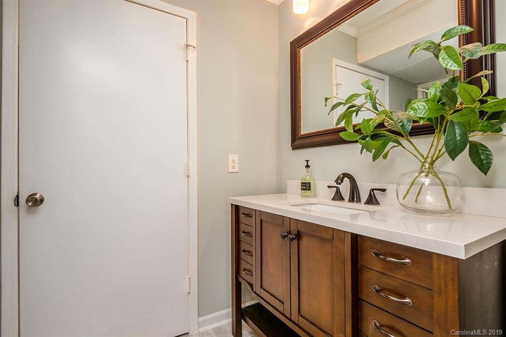 4948 Sardis Road, Unit B Charlotte, NC 28270 - Photo 19 of 30 a bathroom with a granite countertop sink a mirror and a potted plant