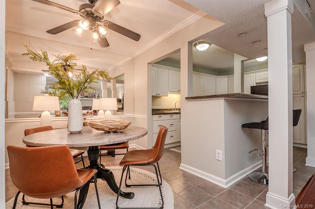 4948 Sardis Road, Unit B Charlotte, NC 28270 - Photo 7 of 30 a dining room with stainless steel appliances kitchen island granite countertop a table chairs and a refrigerator