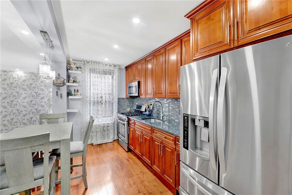 2241 Plumb 1st Street, Unit 5M Brooklyn, NY 11229 - Photo 14 of 24 a kitchen with stainless steel appliances granite countertop a refrigerator a stove and a wooden floors