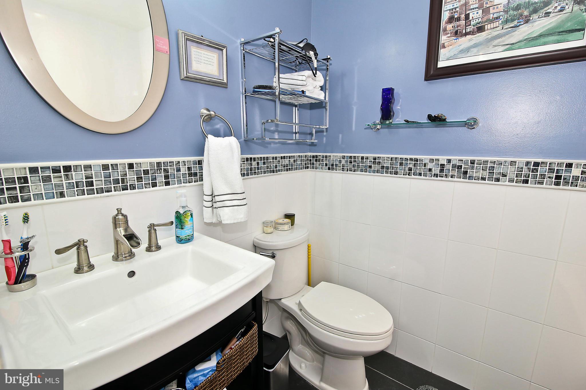 2103 North Rolfe Street, Unit A Arlington, VA 22209 - Photo 17 of 28 a bathroom with a sink a mirror and a toilet