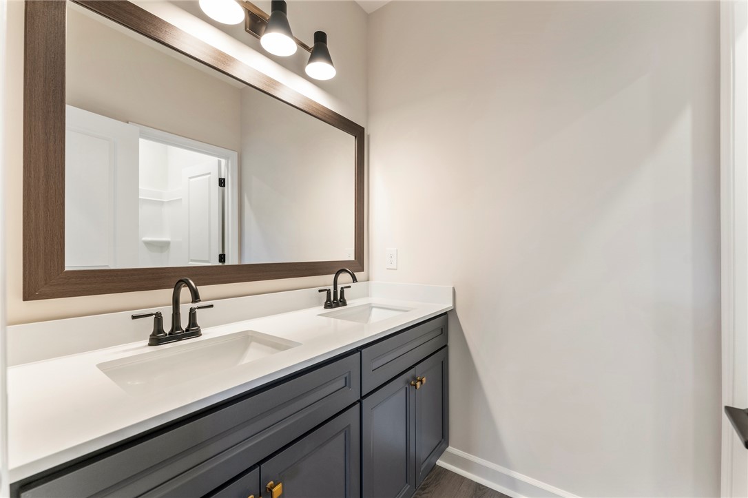 3140 Midway Road Anderson, SC 29621 - Photo 28 of 39 This modern bathroom features a spacious vanity with dual sinks, framed mirror, and elegant fixtures.