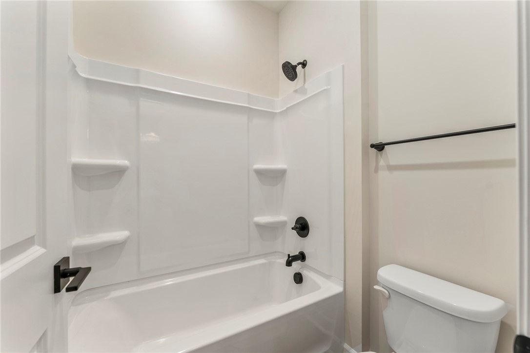 3140 Midway Road Anderson, SC 29621 - Photo 29 of 39 This bathroom showcases a pristine tub and shower combination with sleek dark fixtures.