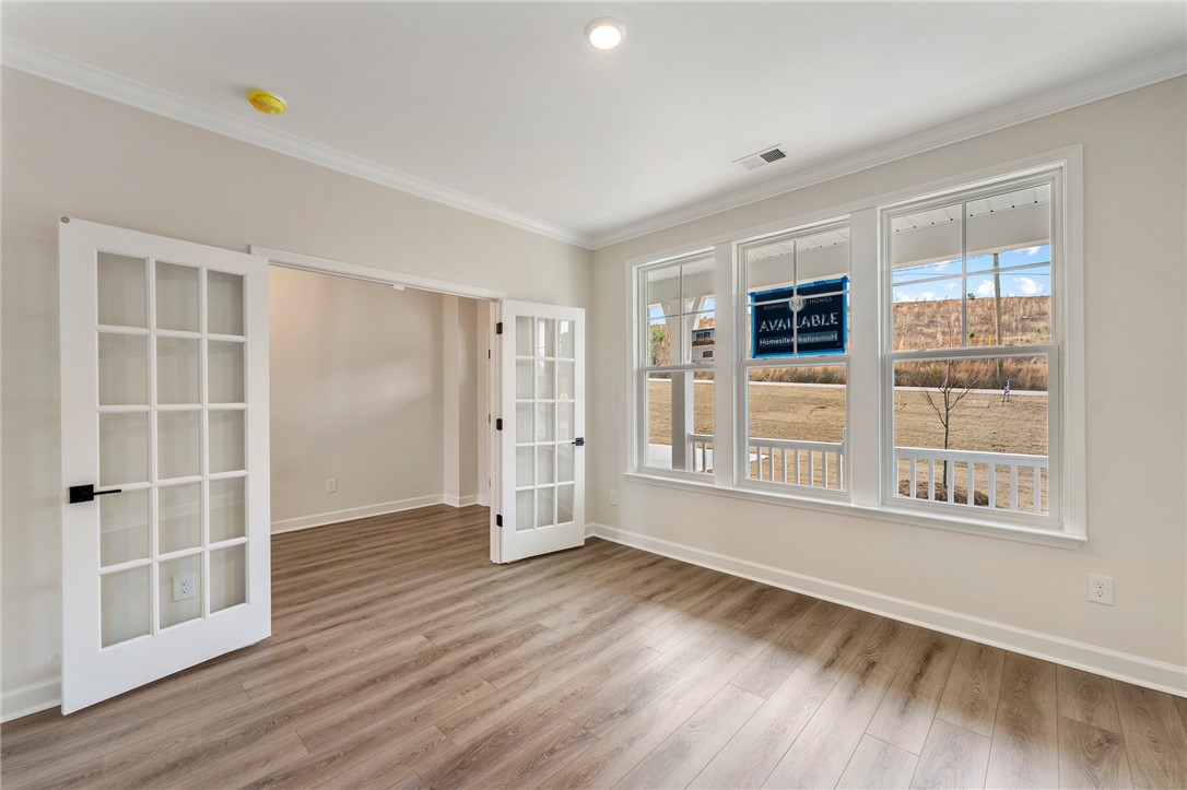 3140 Midway Road Anderson, SC 29621 - Photo 5 of 39 This bright room features elegant glass-paned doors and durable flooring, perfect for a versatile living space.