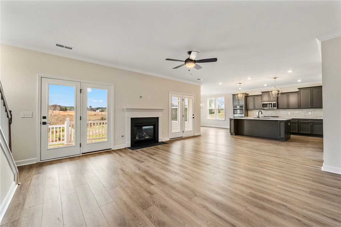 3140 Midway Road Anderson, SC 29621 - Photo 7 of 39 This bright, open-concept living space features warm flooring, a modern kitchen, and an inviting fireplace.