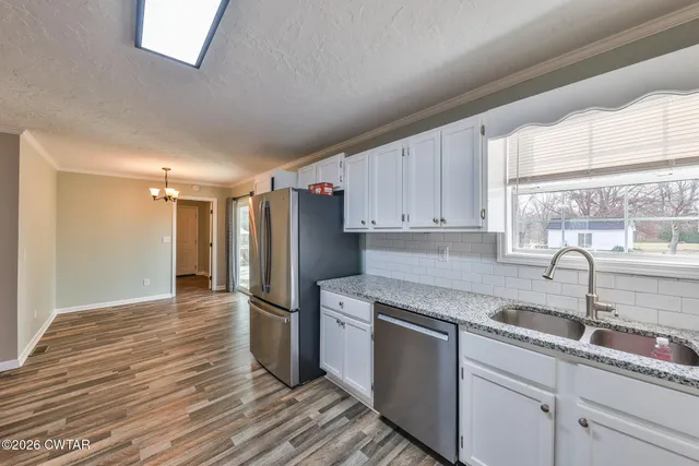 a large kitchen with cabinets stainless steel appliances and a counter space