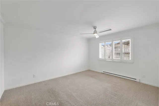 an empty room with windows and ceiling fan