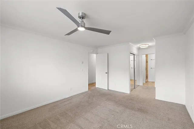 an empty room with ceiling fan and window