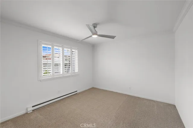 an empty room with a window and a fan