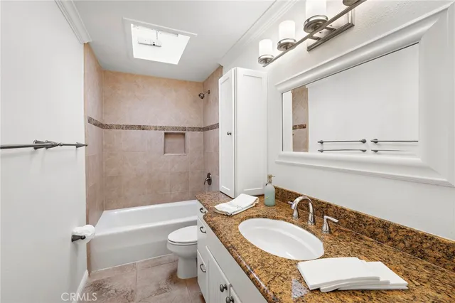 a bathroom with a granite countertop sink toilet a mirror and shower