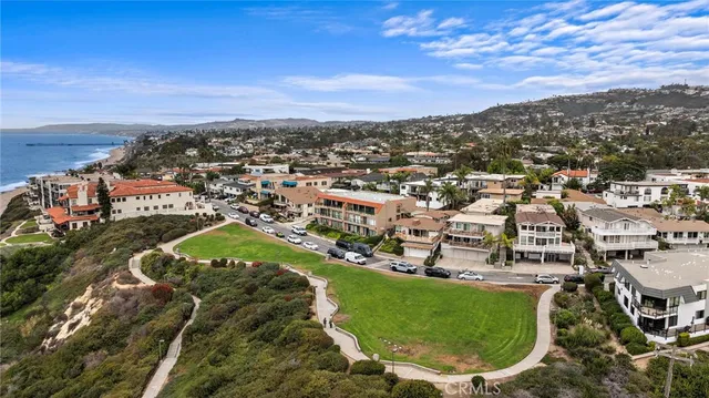 an aerial view of residential houses with outdoor space and ocean view