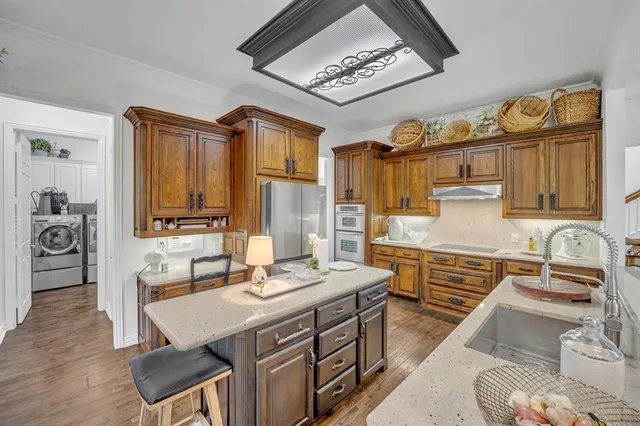 a kitchen with stainless steel appliances granite countertop a sink stove and cabinets