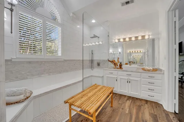a bathroom with a granite countertop sink mirror and a bathtub