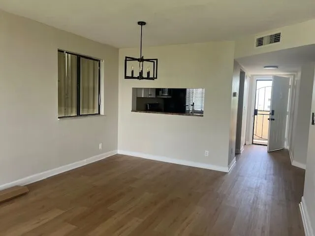 a view of a room with wooden floor and a window