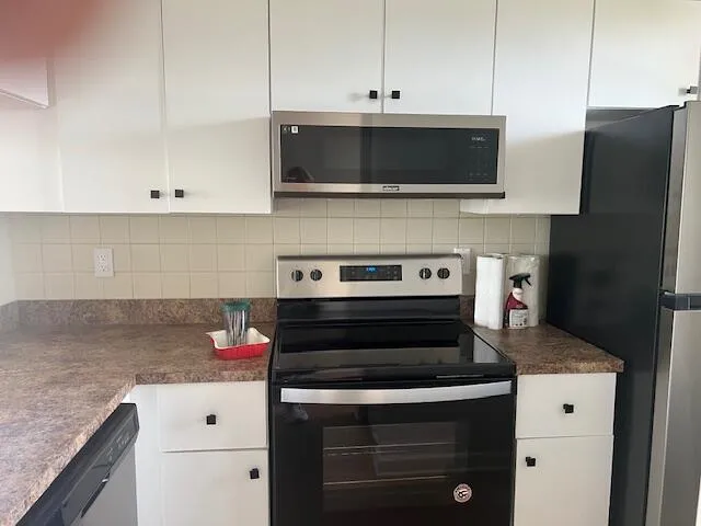 a kitchen with stainless steel appliances granite countertop a stove and a microwave