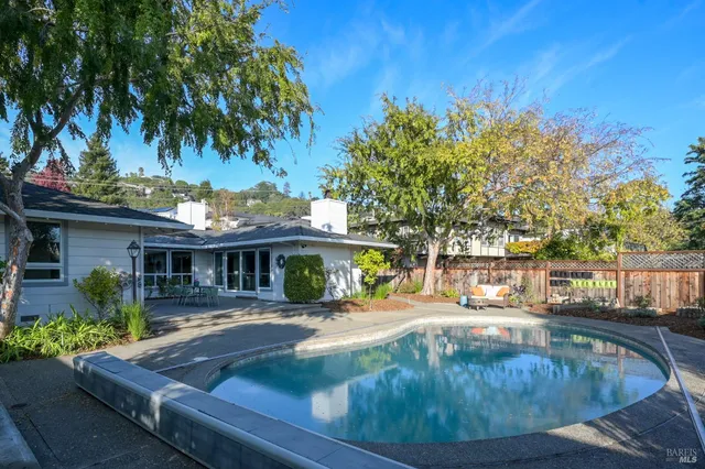 a view of a house with pool and sitting area