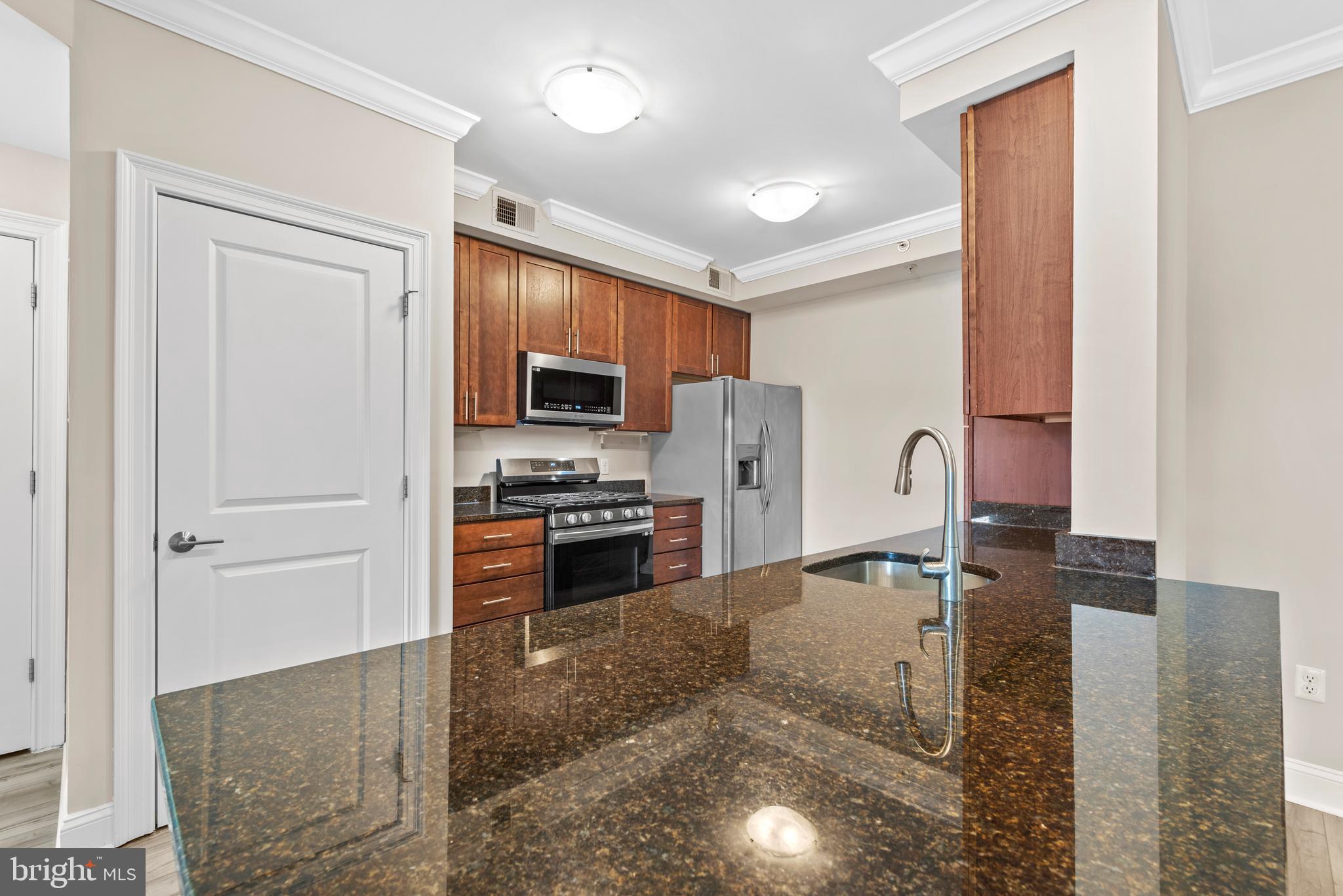 6301 Edsall Road, Unit 424 Alexandria, VA 22312 - Photo 12 of 30 a kitchen with stainless steel appliances granite countertop a refrigerator a stove and a sink with wooden floor