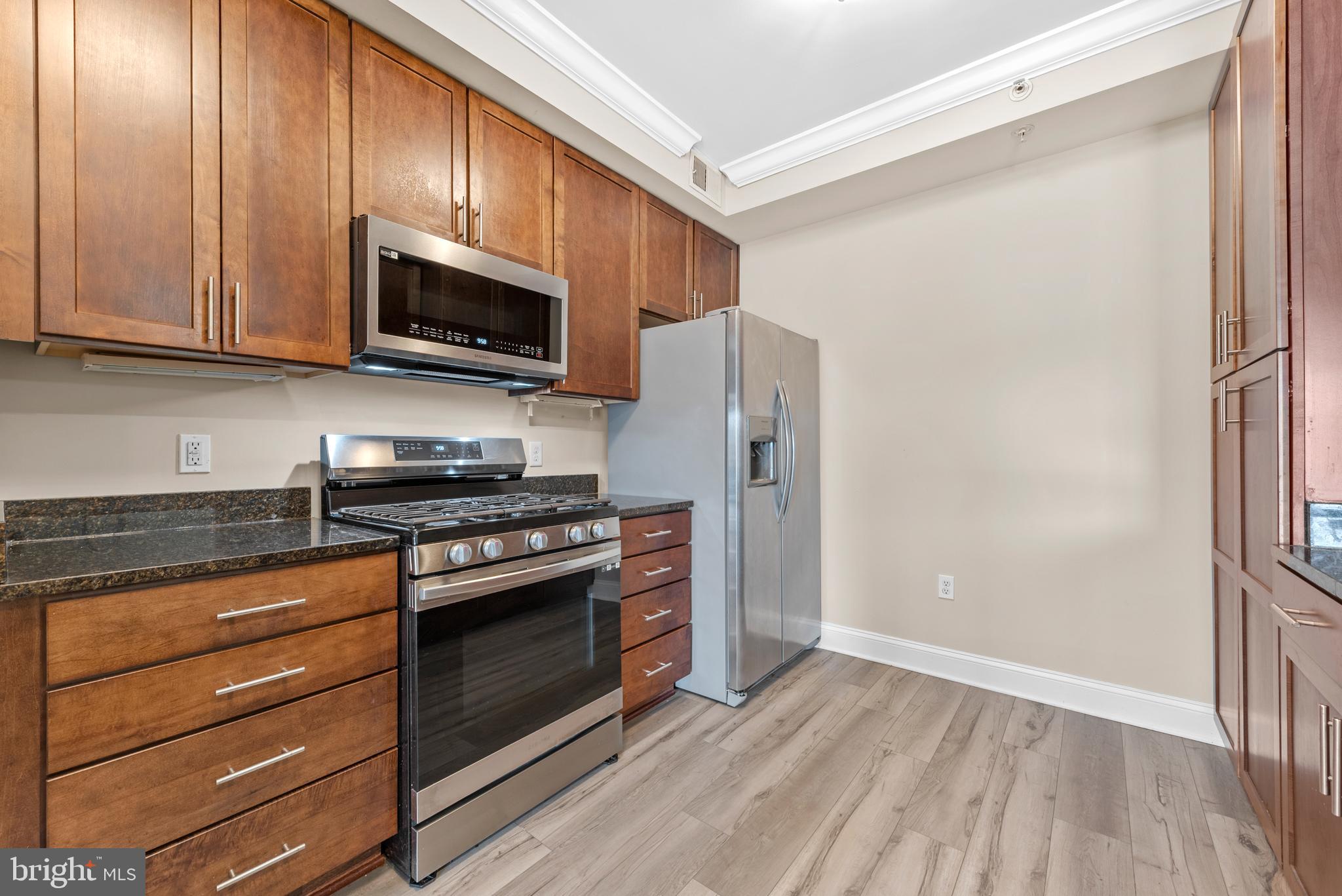 6301 Edsall Road, Unit 424 Alexandria, VA 22312 - Photo 14 of 30 a kitchen with stainless steel appliances granite countertop a stove microwave and refrigerator