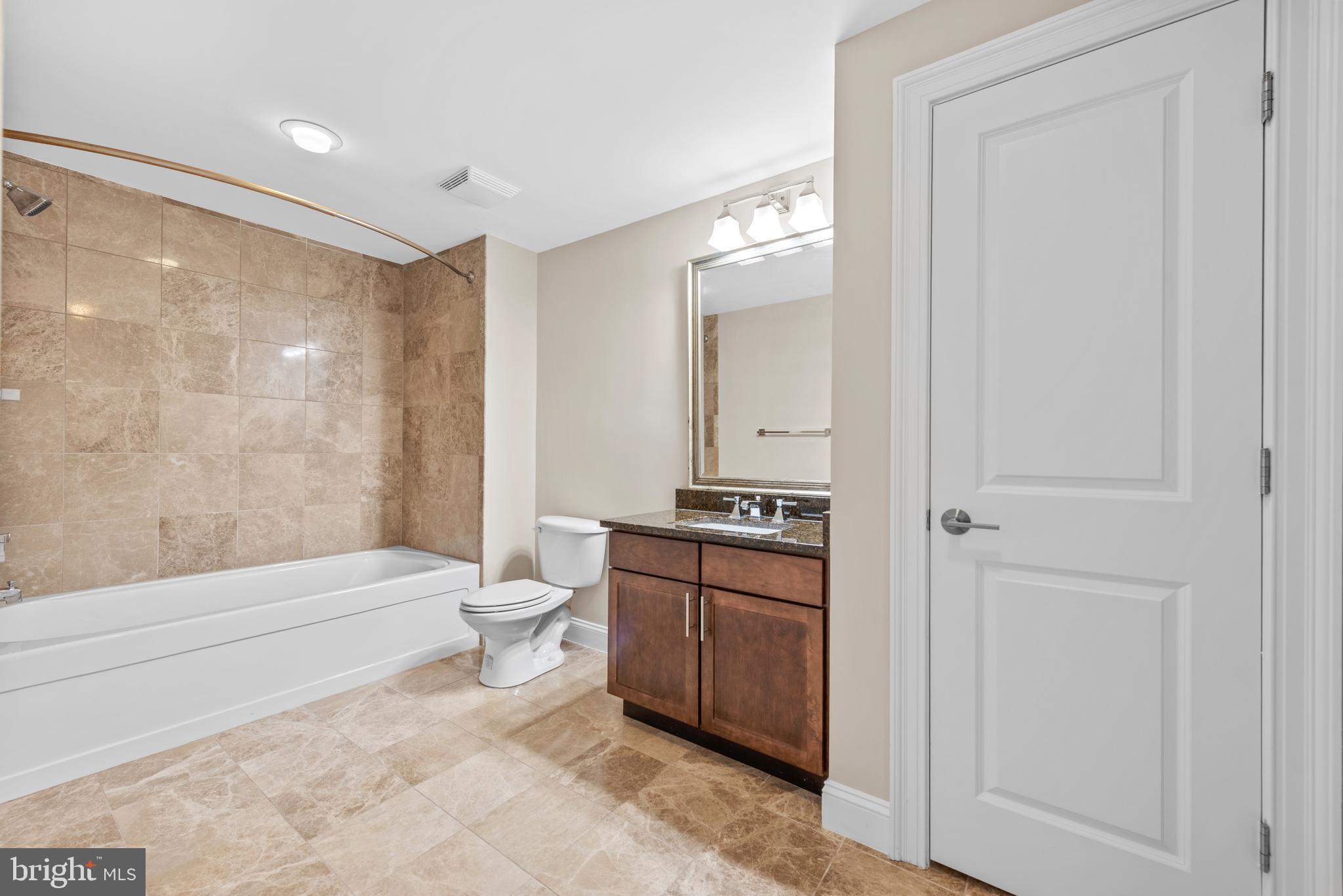 6301 Edsall Road, Unit 424 Alexandria, VA 22312 - Photo 25 of 30 a bathroom with a granite countertop sink a toilet and shower